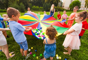 Dzieci bawiące się kolorową chustą animacyjną na świeżym powietrzu – LabStar Kids